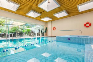 Una piscina techada, sillones reclinables de piscina
