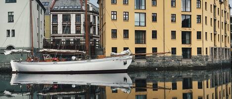 A historic building with multiple windows and a reflection in the water.