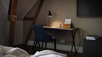 Un dormitorio con escritorio, silla y cama.