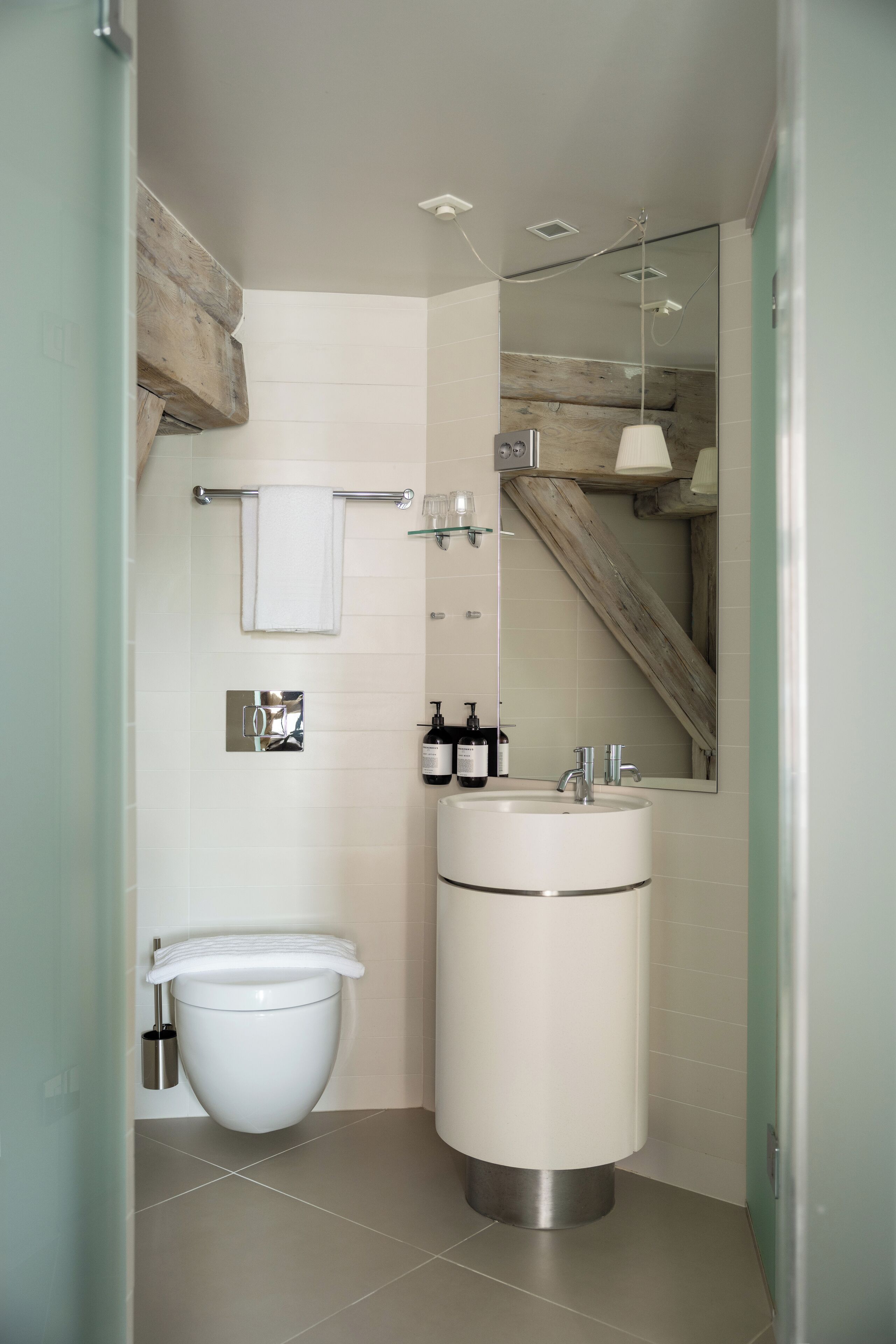A modern bathroom with a toilet, sink, and mirror.