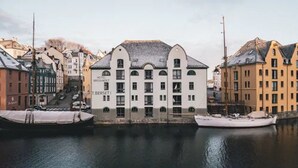 A historic building with a symmetrical facade, multiple windows, and a central entrance. - Hotel Brosundet (Ålesund)