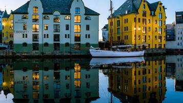 A waterfront hotel with a classic architectural style, featuring multiple stories and large windows.