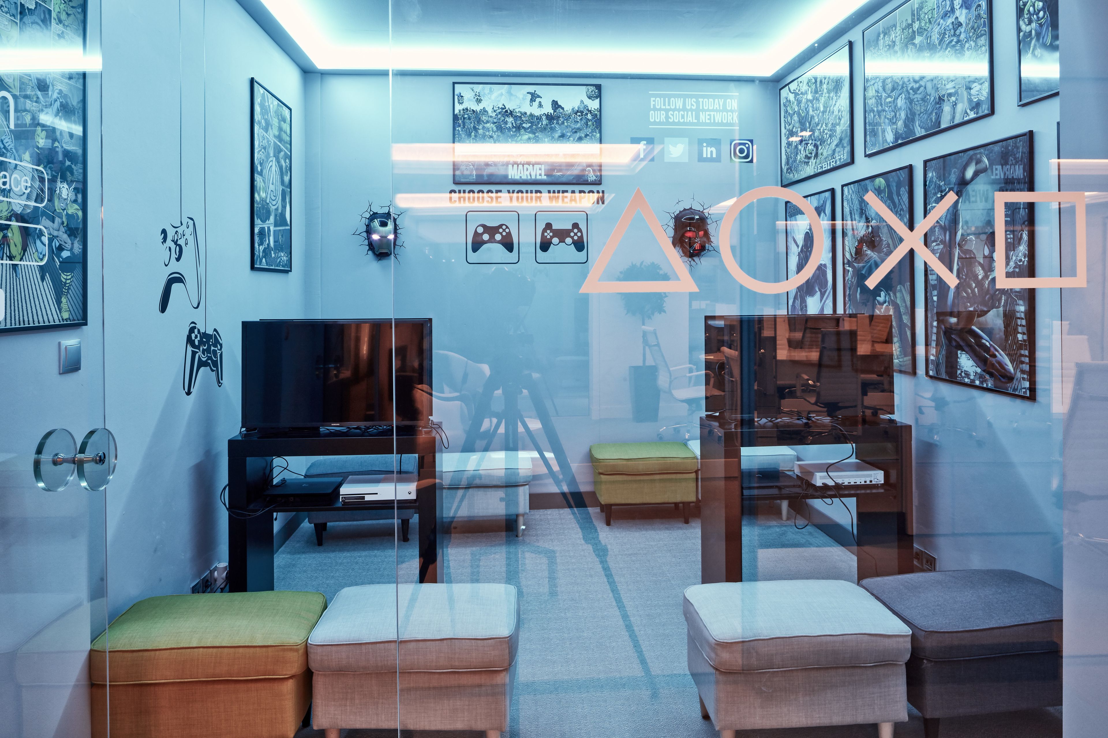 A modern room with a glass partition, a desk, a chair, and a television.