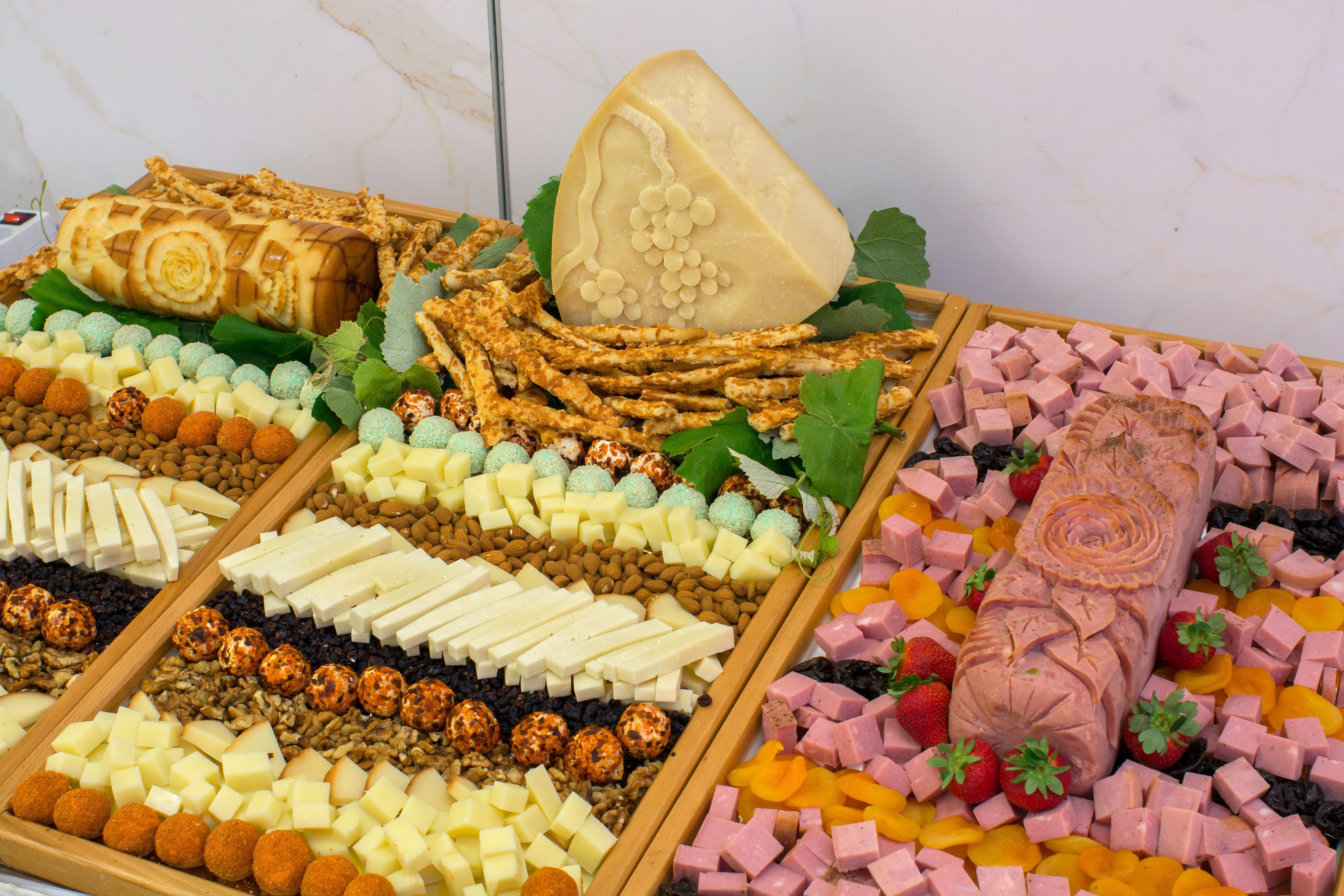 Une variété de fromages, de charcuteries et de fruits secs disposés sur des planches en bois.