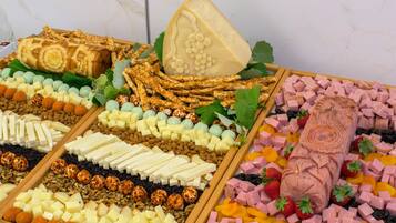 Eine Auswahl an Käse, Fleisch und Nüssen, ansprechend auf Holzbrettern angerichtet.