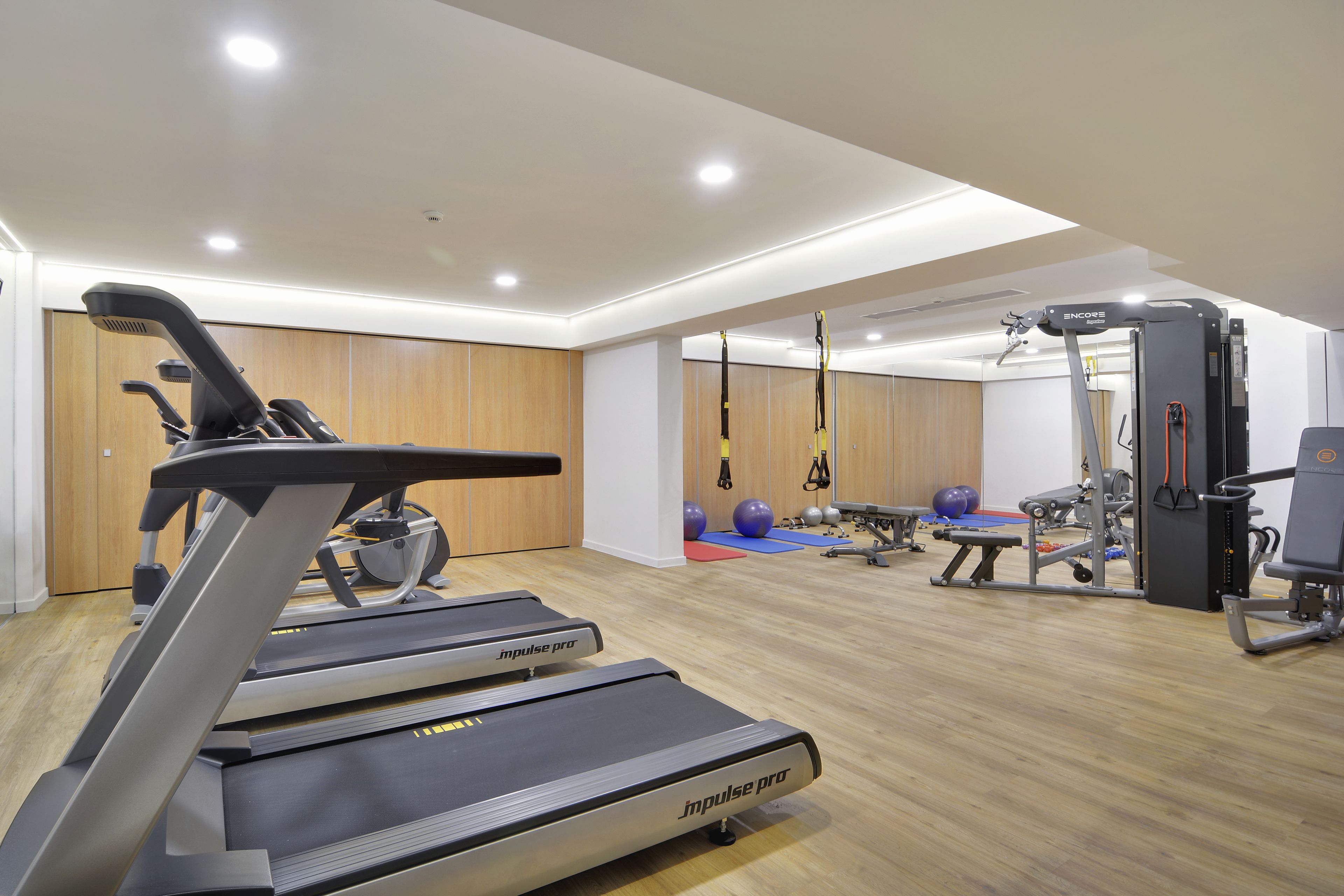 A modern gym with treadmills, exercise balls, and various fitness equipment.
