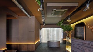 A modern interior with a herringbone floor, a reception desk, and a visible elevator sign. - Hotel Rėja a member of Design Hotels (Klaipeda)