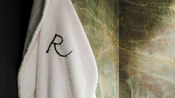 A white towel with a monogram hanging on a hook.