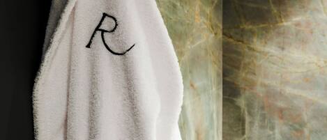 A white towel with a monogram hanging on a hook.