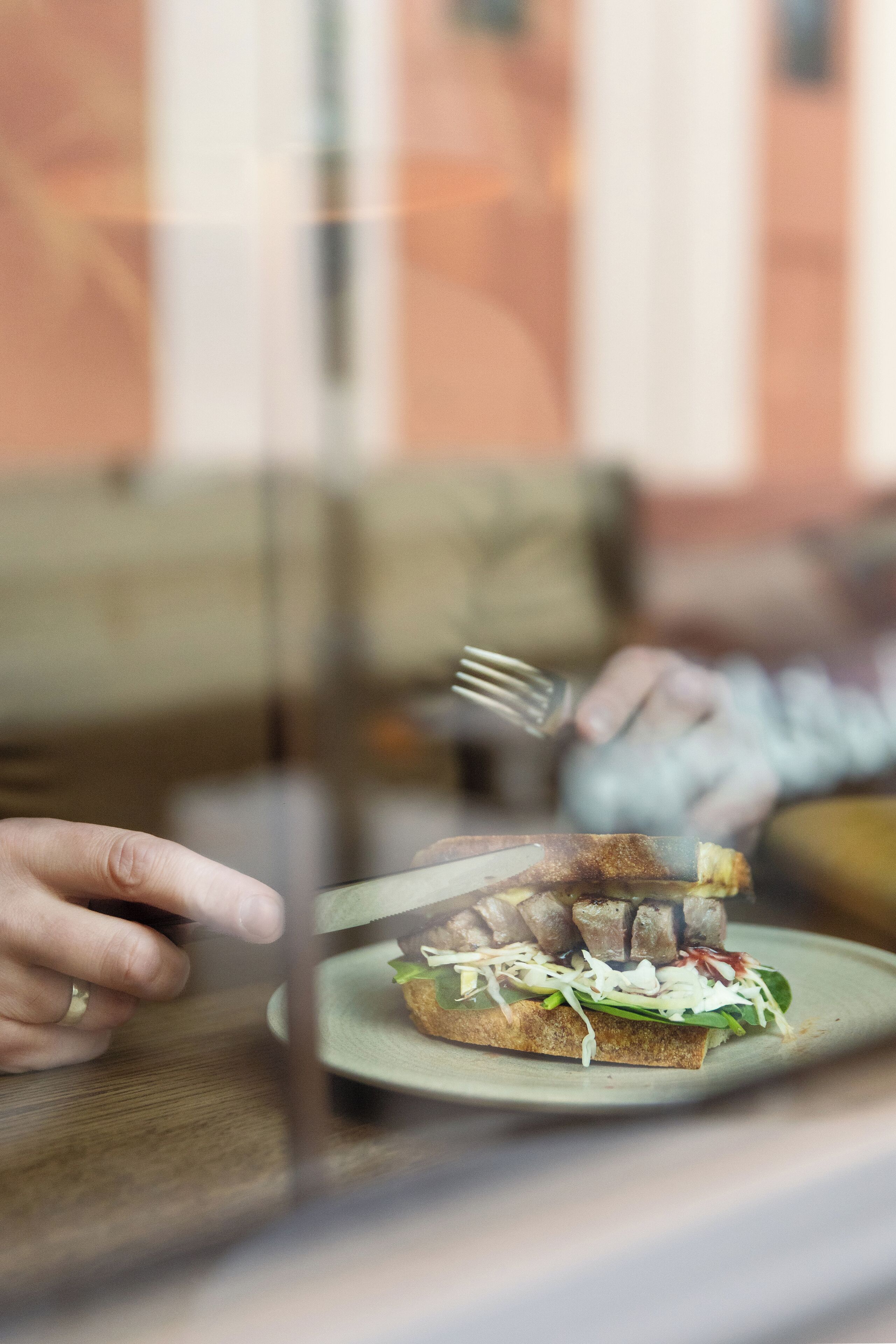 Une vue rapprochée d’un sandwich sur une assiette, avec une fourchette à côté.