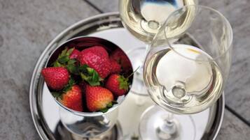 Un plateau avec deux verres à vin et un bol de fraises.