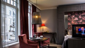 A hotel room with a dining area, a TV, and a window with curtains. - Frogner House - Skovveien (Oslo)
