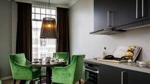 A modern kitchen with a dining table, chairs, and a pendant light. - Frogner House - Skovveien (Oslo)