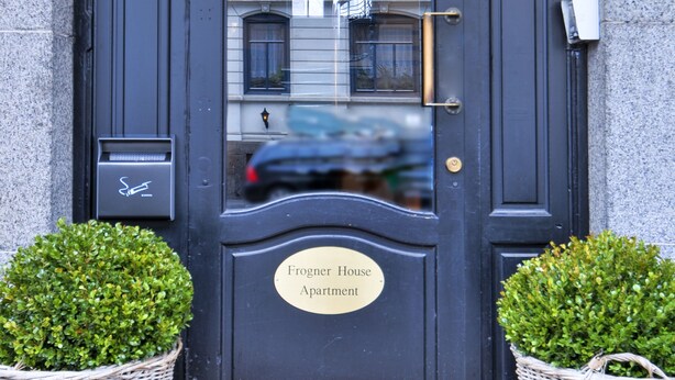 A black door with a frosted glass panel, a nameplate reading "Frogner House Apartment," and two wicker baskets on either side. - Frogner House - Skovveien (Oslo)