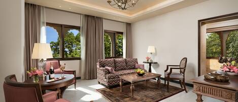 A spacious living room with a sofa, chairs, a coffee table, and a chandelier.