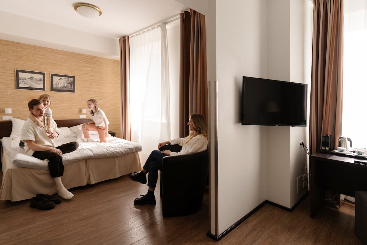 Ein Hotelzimmer mit Bett, Sofa, Fernseher und Schreibtisch mit Kaffeemaschine.