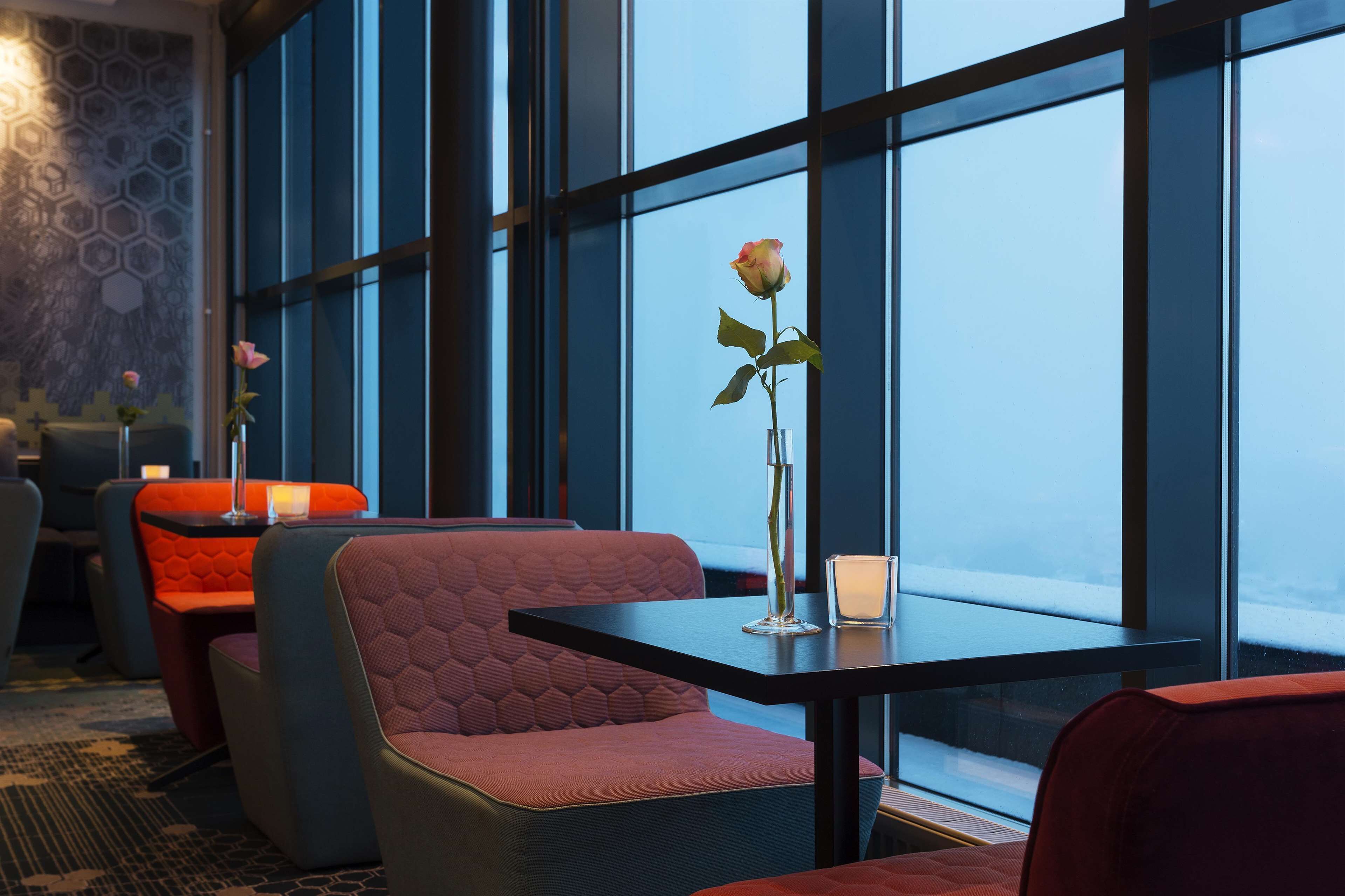 Ein modernes Interieur mit einer Sitzecke, ausgestattet mit gepolsterten Bänken und einem Tisch mit Blumen in einer Vase.