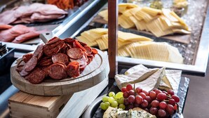 A variety of meats, cheeses, and grapes displayed on a table.