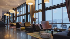 A spacious lobby with modern seating, large windows, and a view of the city. - Scandic Narvik (Narvik)