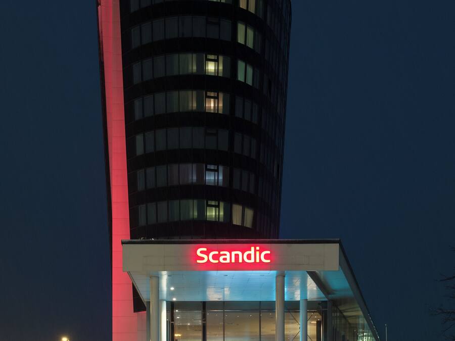 A tall building with a prominent 'Scandic' sign at the top and entrance.
