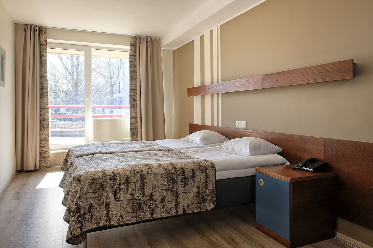 Une chambre d’hôtel avec un lit, une table de chevet et une vue sur l’extérieur.