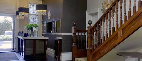 A grand staircase with wooden balusters and a carpeted landing.