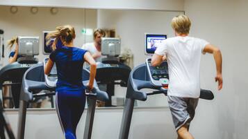 A gym with treadmills and a mirrored wall.