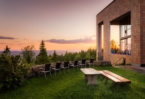 An outdoor seating area with chairs and a table, overlooking a scenic view of trees and a distant landscape. - Soria Moria Hotell (Oslo)