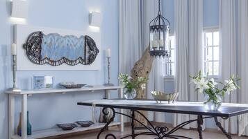 A well-lit room with a large table, decorative wall art, and a hanging lantern.