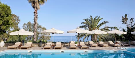 Piscine extérieure, parasols de plage, chaises longues