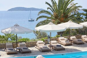 Una piscina al aire libre, sombrillas, tumbonas