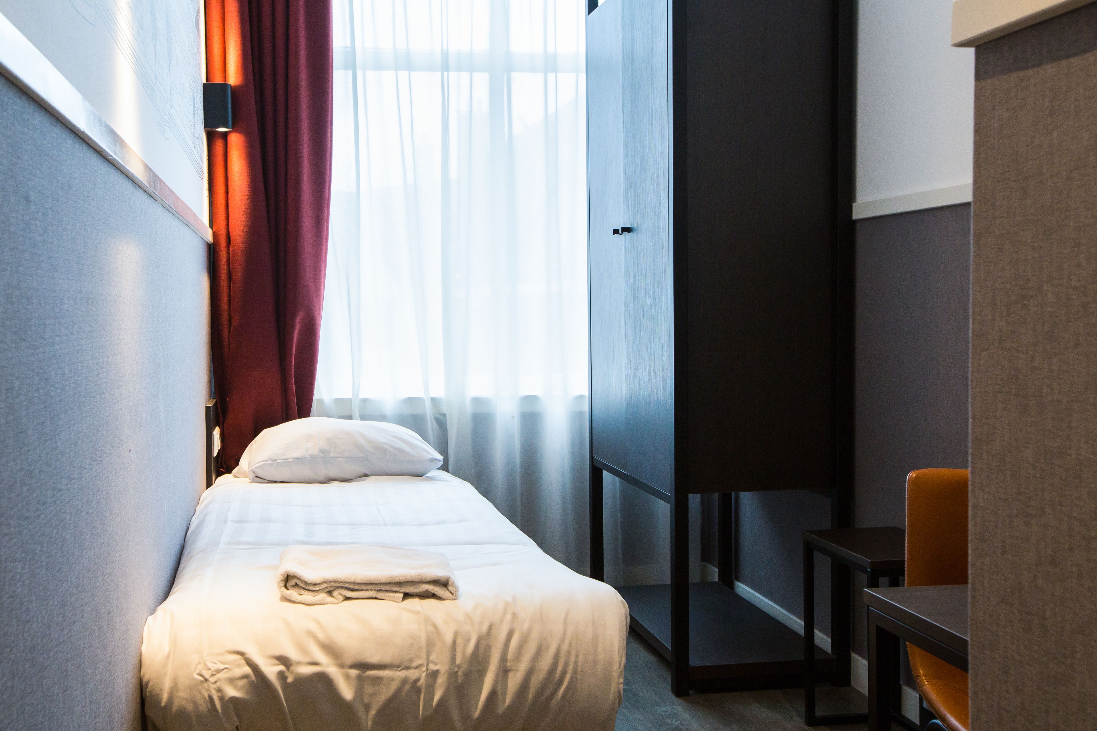 Una habitación de hotel con una cama, un escritorio y una silla.