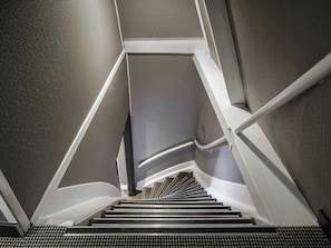 A spiral staircase with a handrail and a textured wall. - ibis Styles Amsterdam Amstel (Amsterdam)