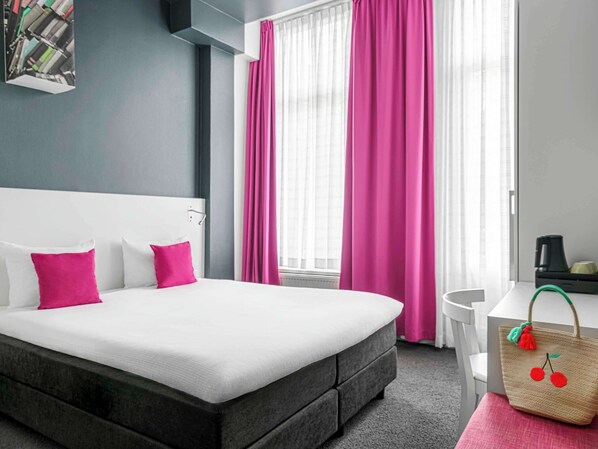 Relax in a spacious room with a large bed, desk, and coffee maker.