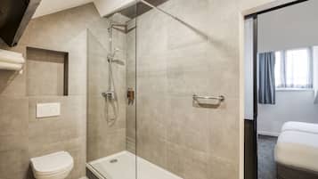 A modern bathroom with a glass-enclosed shower, a toilet, and a bathtub.