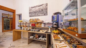 A breakfast buffet with various food items and a coffee machine. - Lilium Hotel (Florence)