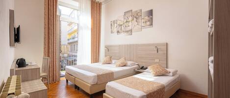 Habitación triple | Edredón, minibar, caja de seguridad en la habitación y escritorio