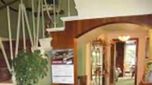 Une pièce avec une chaise en bois, une petite table, une plante en pot et un escalier.