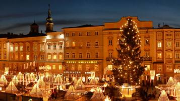 Ein Hotel mit einem gut sichtbaren Schild, einer großen Weihnachtstanne und beleuchteten Dekorationen.