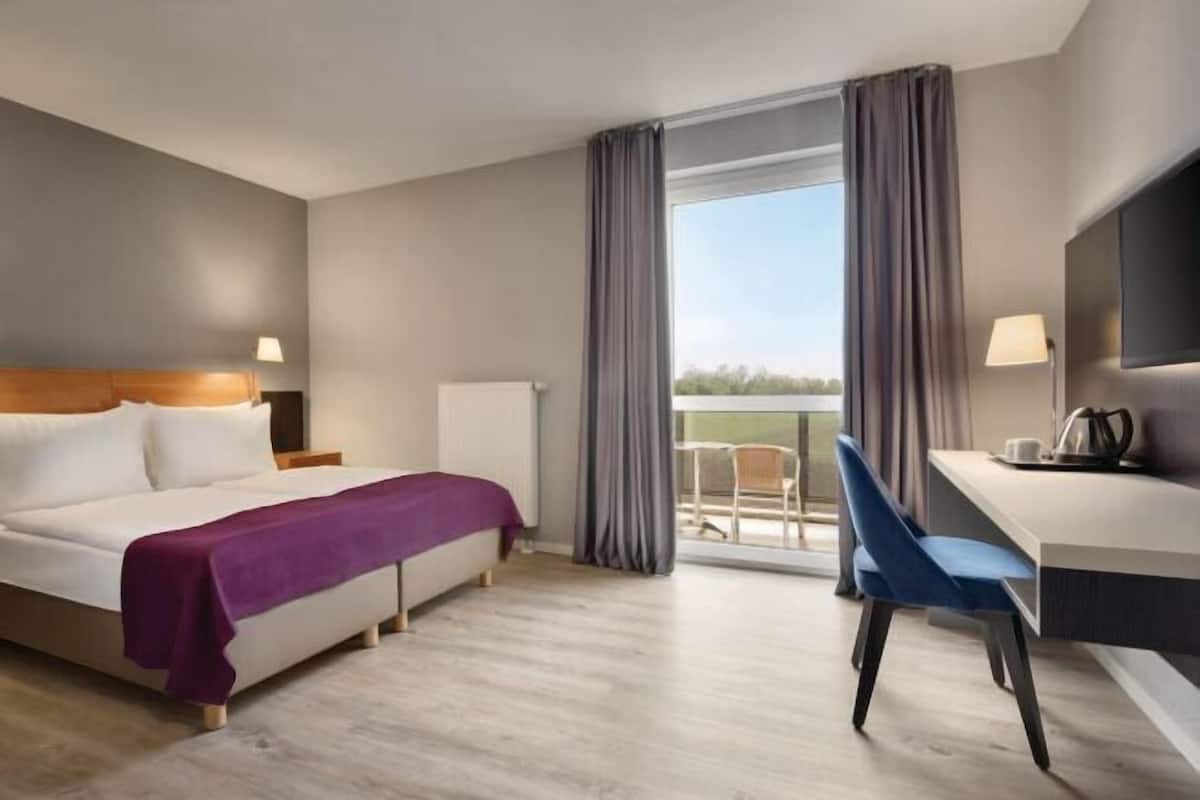 Biancheria da letto ipoallergenica, una scrivania, tende oscuranti