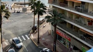 A multi-story hotel with balconies overlooking a beach. - Hôtel Courbet (Antibes)