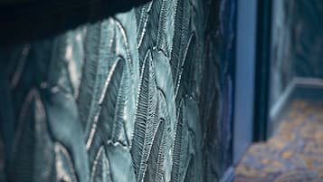 Un gros plan d’un mur à texture, orné de motifs de lignes verticales, et d’un tapis à motifs.