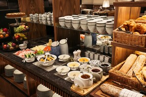 A buffet with various food items and utensils. - Hotel Schani Salon (Vienna)