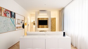 Una habitación de hotel moderna con una cama grande, un televisor de pantalla plana, un mapa en la pared y vistas a la ciudad.