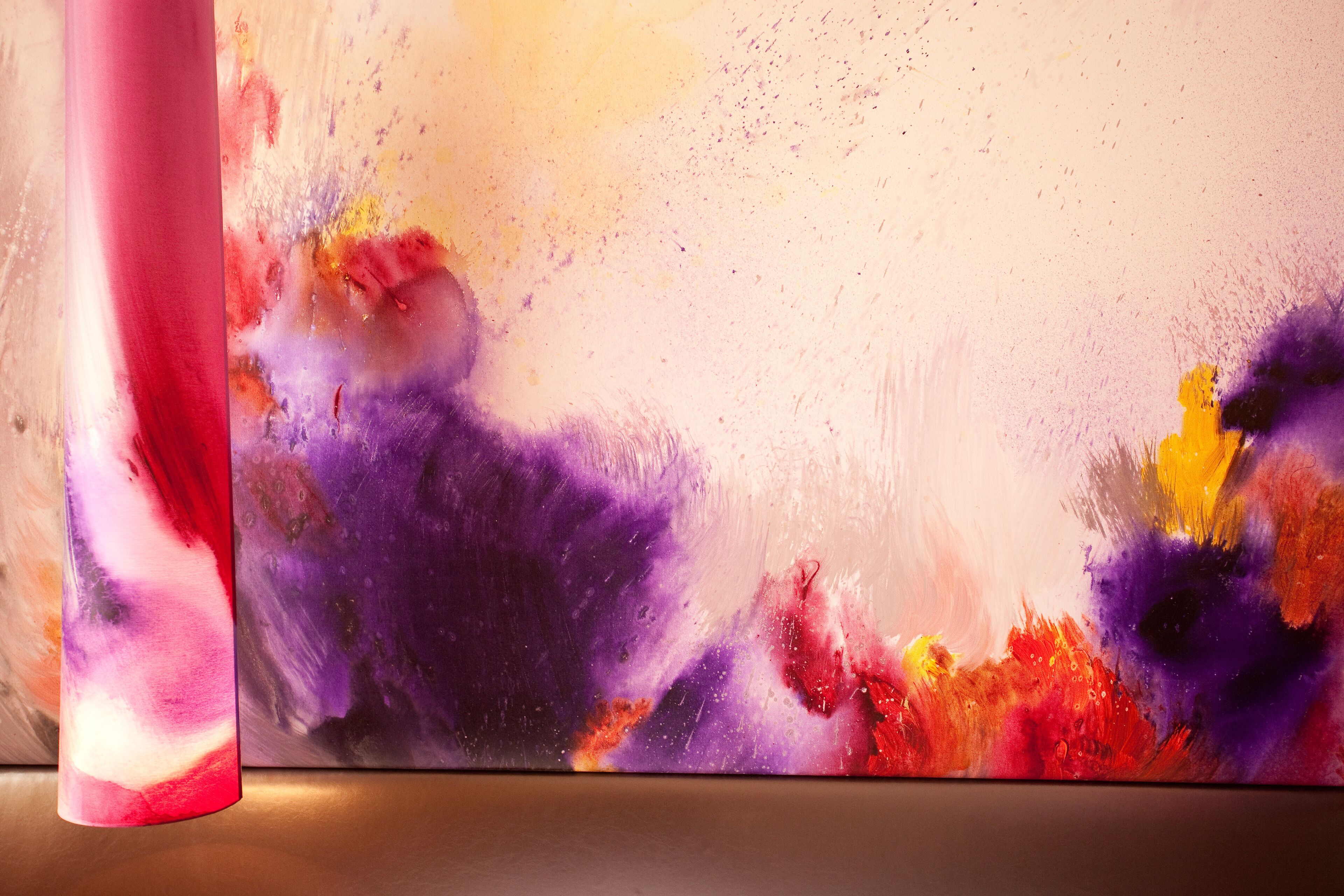 A close-up of a colorful abstract painting with vibrant hues of red, purple, yellow, and orange.