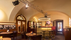 A bar area with tables, chairs, and a bar counter. - Austria Classic Hotel Wien (Vienna)