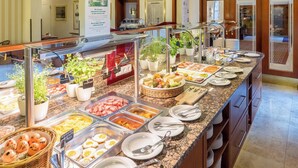 A buffet with various food items and utensils, including plates, bowls, and a variety of dishes. - Austria Classic Hotel Wien (Vienna)