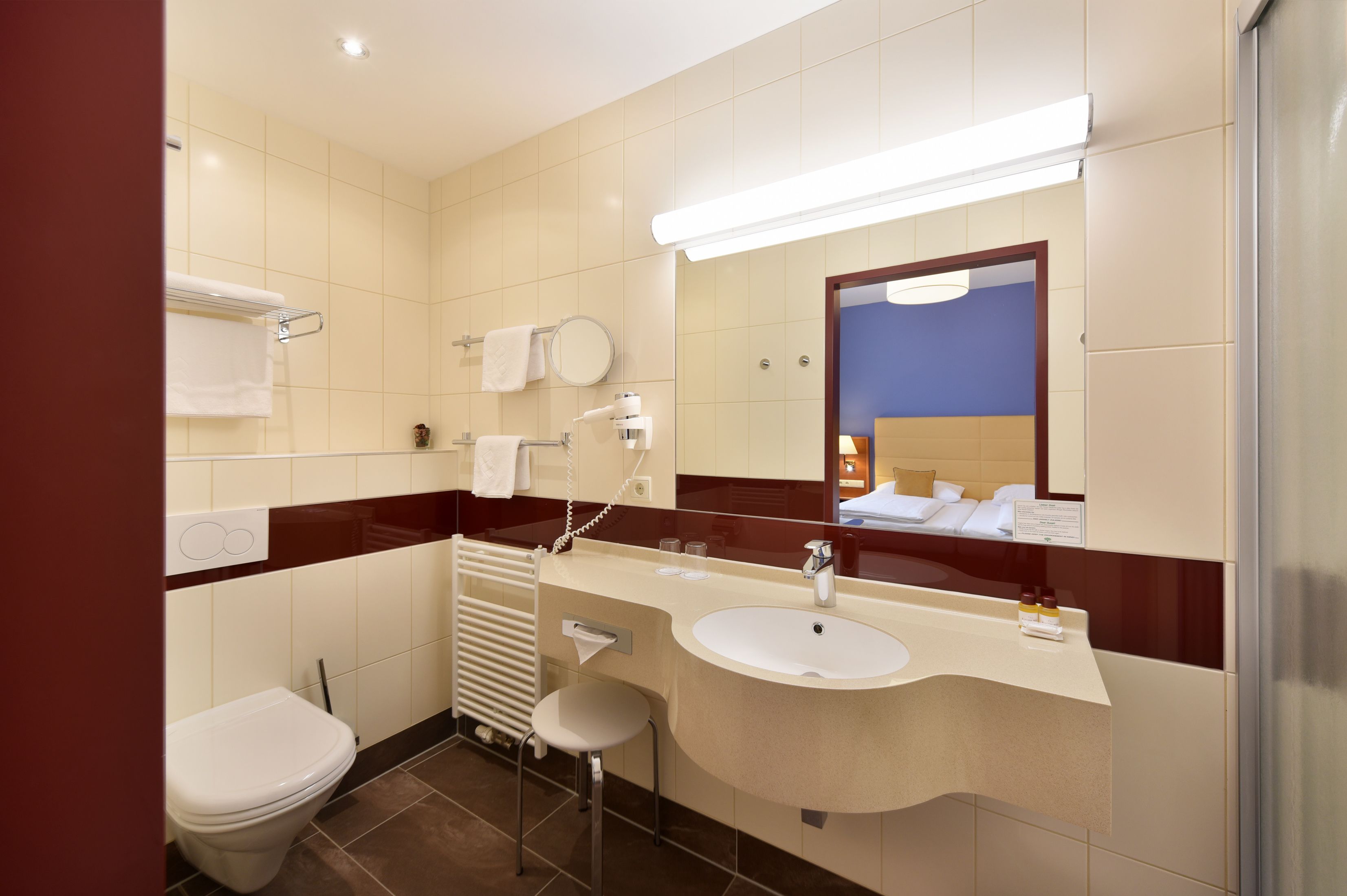Un bagno moderno con il water, lavandino e specchio.