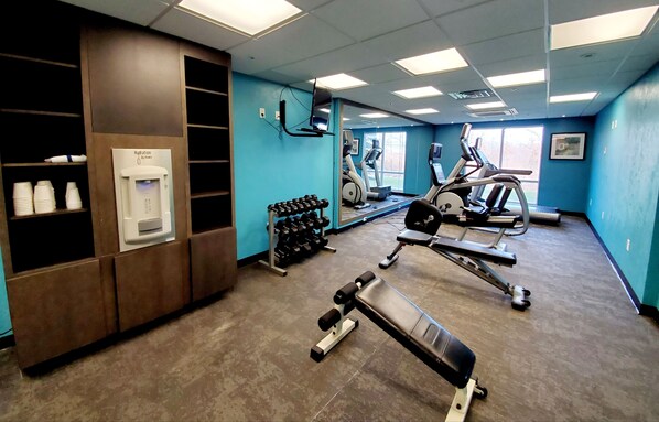 A gym with exercise equipment, a hydration station, and a mirror. - Fairfield Inn & Suites by Marriott Cleveland Avon (Avon)