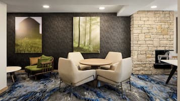 A modern lounge area with a stone wall, a fireplace, and a large forest mural.